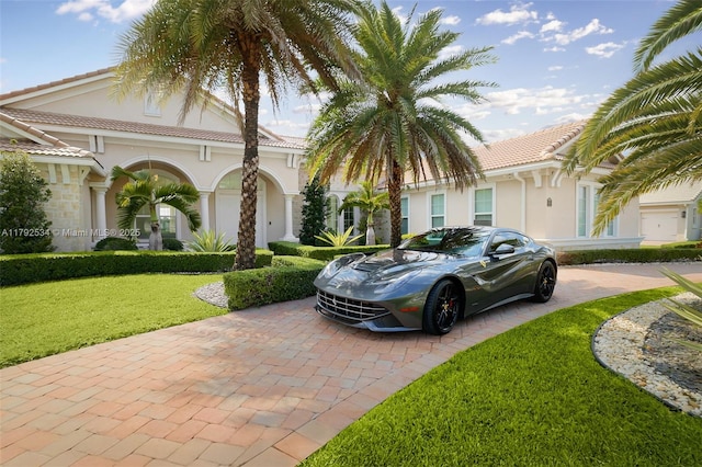 4991 E Sterling Ranch Cir, Davie, FL 33314 - mediterranean / spanish house featuring stucco siding, decorative driveway, a front lawn, and a tile roof