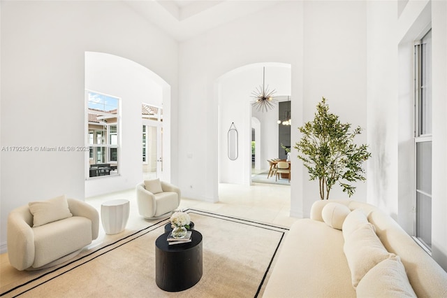 4991 E Sterling Ranch Cir, Davie, FL 33314 - living room featuring arched walkways, a high ceiling, and baseboards