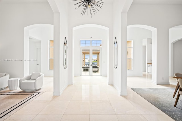 4991 E Sterling Ranch Cir, Davie, FL 33314 - foyer with a towering ceiling, light tile patterned floors, baseboards, arched walkways, and a chandelier
