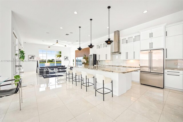 4991 E Sterling Ranch Cir, Davie, FL 33314 - kitchen featuring high end fridge, wall chimney range hood, a breakfast bar, a sink, and recessed lighting