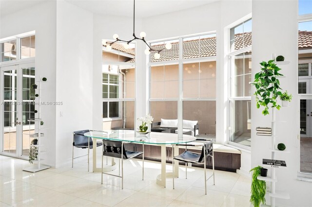 4991 E Sterling Ranch Cir, Davie, FL 33314 - dining space featuring healthy amount of natural light, tile patterned flooring, a chandelier, and a towering ceiling