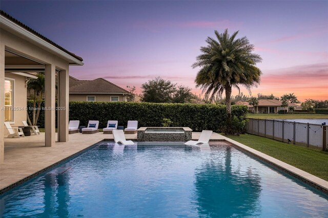 4991 E Sterling Ranch Cir, Davie, FL 33314 - pool at dusk with a patio area, a fenced backyard, and an in-ground hot tub
