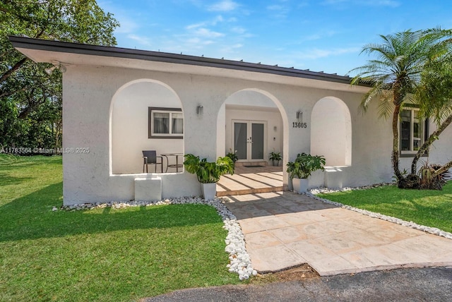 13605 SW 73rd Ave, Palmetto Bay, FL 33158 - view of front facade featuring french doors, a front yard, stucco siding, and a porch