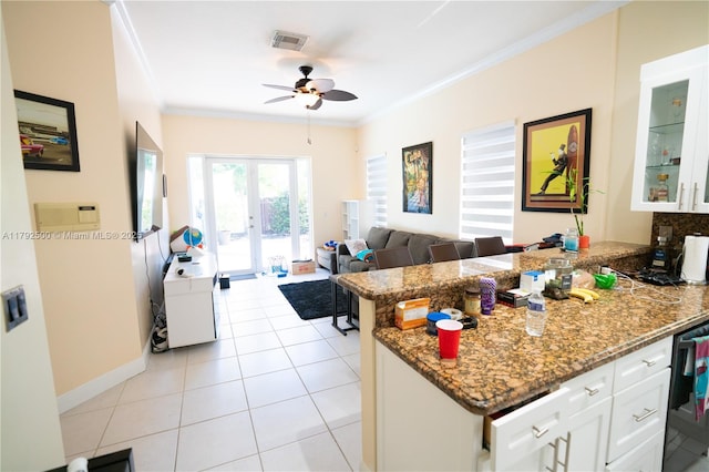 kitchen featuring ceiling fan, french doors, a peninsula, visible vents, and ornamental molding