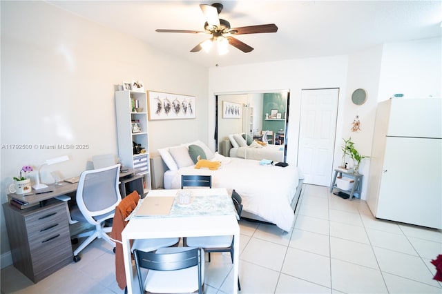 bedroom featuring freestanding refrigerator, a ceiling fan, and light tile patterned floors