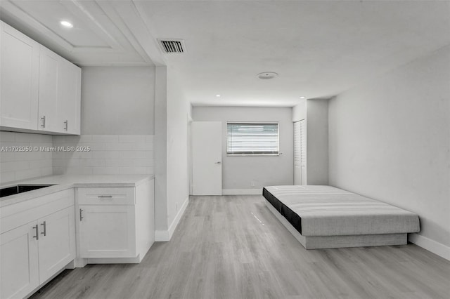 bedroom featuring light wood-style floors, baseboards, a closet, and visible vents