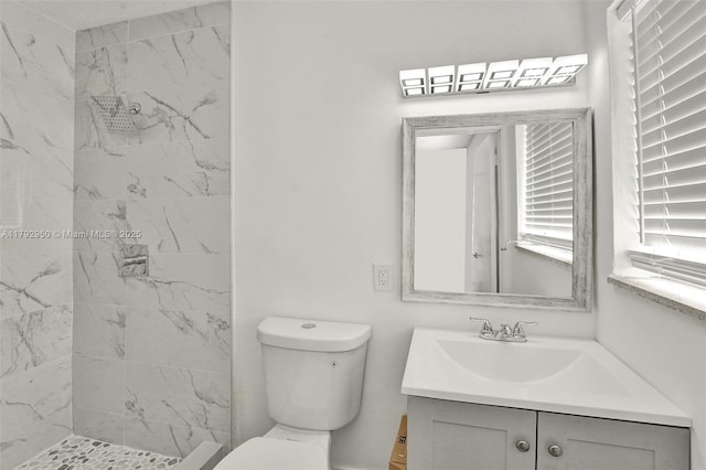 full bath with vanity, toilet, and a marble finish shower