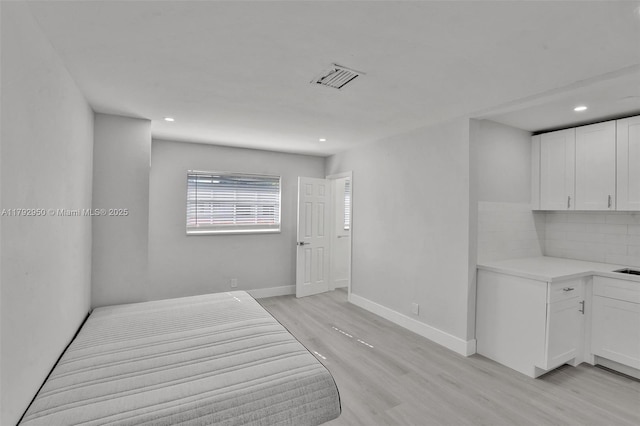 unfurnished bedroom featuring baseboards, recessed lighting, light wood-style flooring, and visible vents
