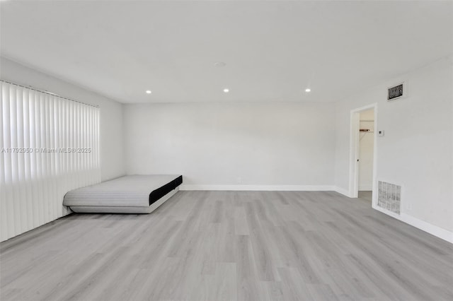 unfurnished bedroom with visible vents, recessed lighting, light wood-style flooring, and baseboards