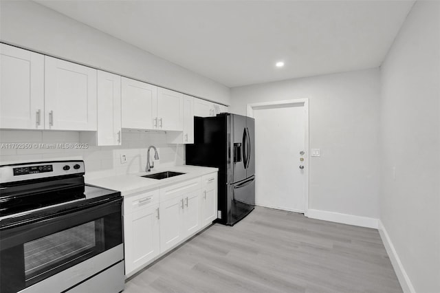 kitchen with black fridge with ice dispenser, electric range, baseboards, light countertops, and a sink