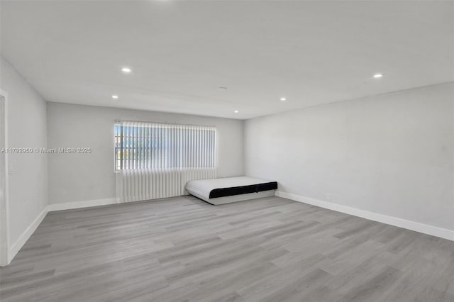 unfurnished bedroom featuring baseboards, recessed lighting, and wood finished floors