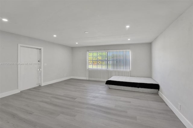 unfurnished bedroom with recessed lighting, baseboards, and wood finished floors