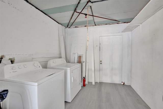 laundry room featuring laundry area, light wood finished floors, and washer and dryer