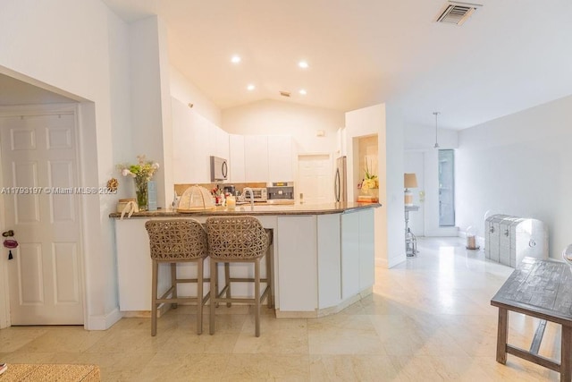 1558 Sunset Way, Weston, FL 33327 - kitchen featuring visible vents, white cabinets, a peninsula, lofted ceiling, and stainless steel fridge