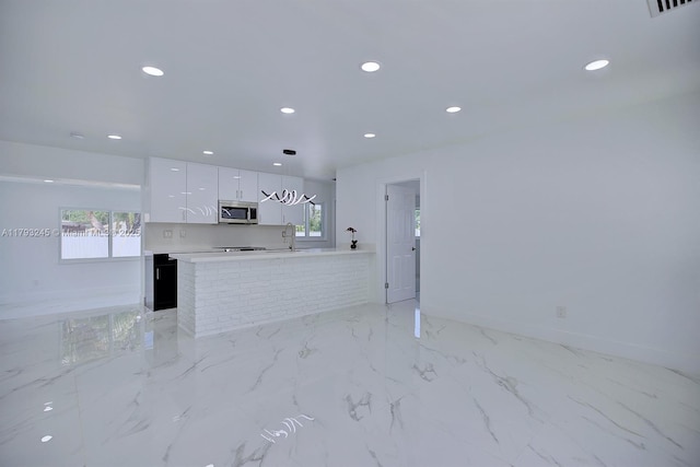 kitchen with white cabinets, a sink, recessed lighting, stainless steel microwave, and modern cabinets