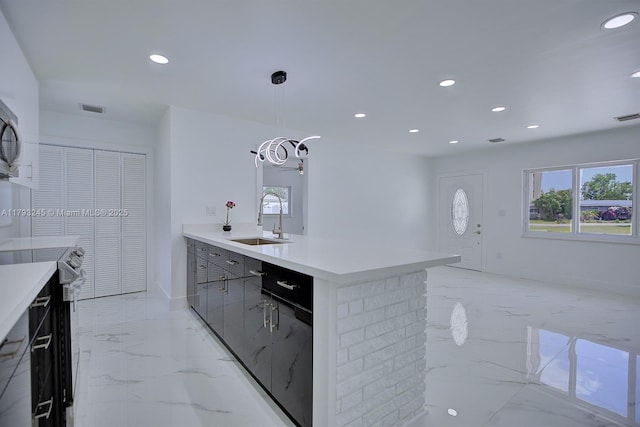 kitchen featuring visible vents, marble finish floor, modern cabinets, light countertops, and a sink