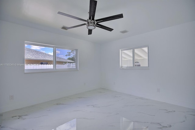 spare room featuring visible vents, marble finish floor, baseboards, and ceiling fan