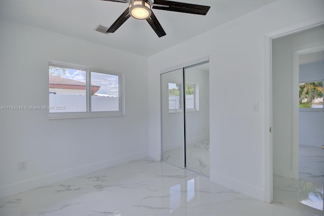 unfurnished bedroom featuring baseboards, a closet, and marble finish floor