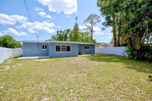 back of house featuring a fenced backyard, stucco siding, a yard, and a patio area