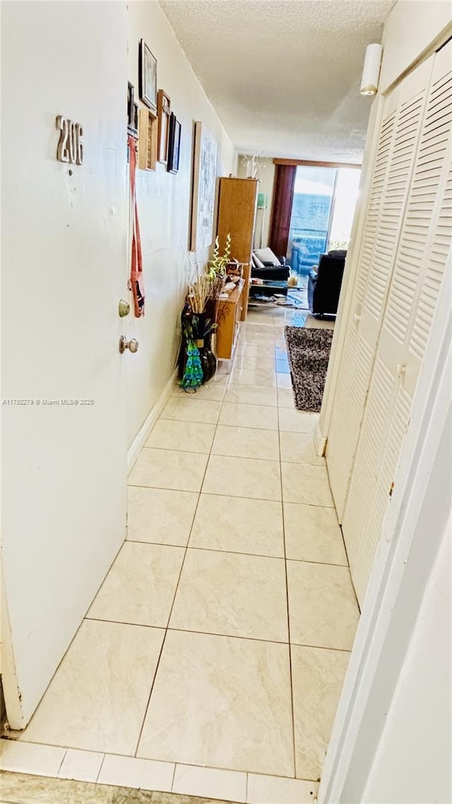 7705 Abbott Ave Unit 206, Miami Beach, FL 33141 - hall with a textured ceiling and light tile patterned flooring