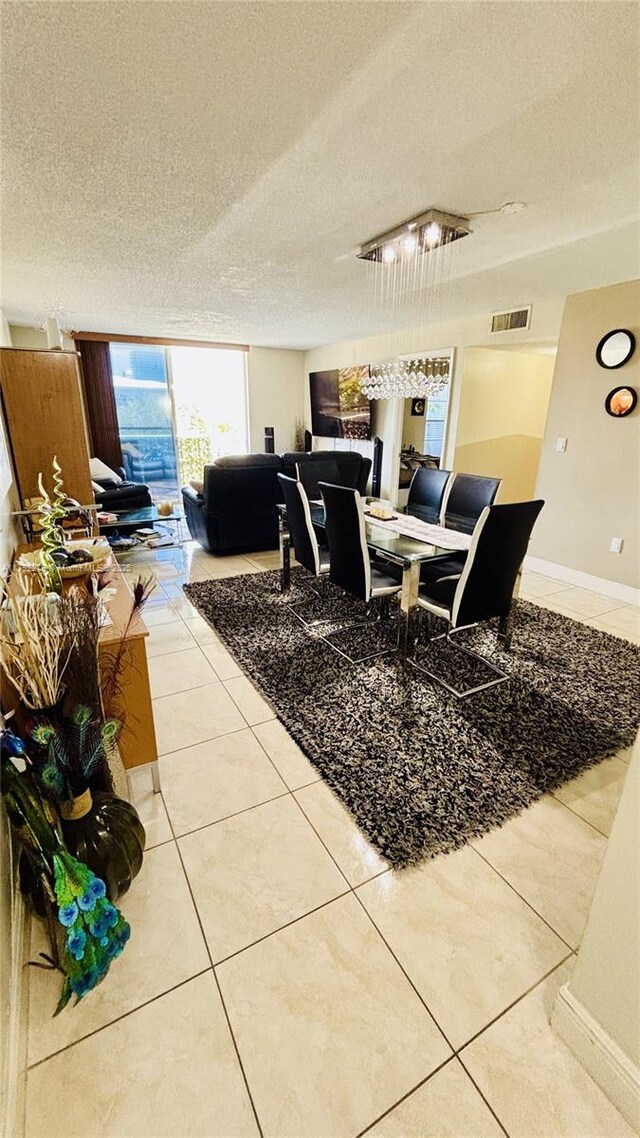 7705 Abbott Ave Unit 206, Miami Beach, FL 33141 - tiled dining area featuring a textured ceiling, visible vents, and baseboards
