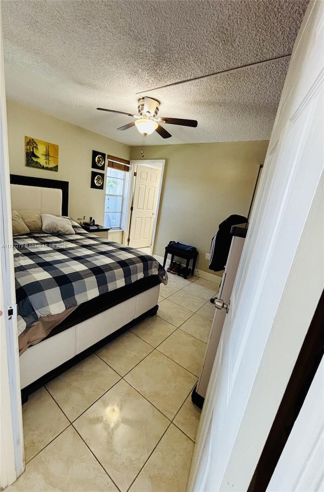 7705 Abbott Ave Unit 206, Miami Beach, FL 33141 - bedroom with baseboards, a ceiling fan, a textured ceiling, and light tile patterned floors