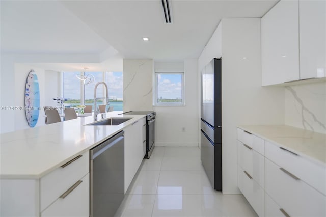 10275 Collins Ave Unit 731, Bal Harbour, FL 33154 - kitchen with modern cabinets, stainless steel dishwasher, a sink, freestanding refrigerator, and white cabinetry
