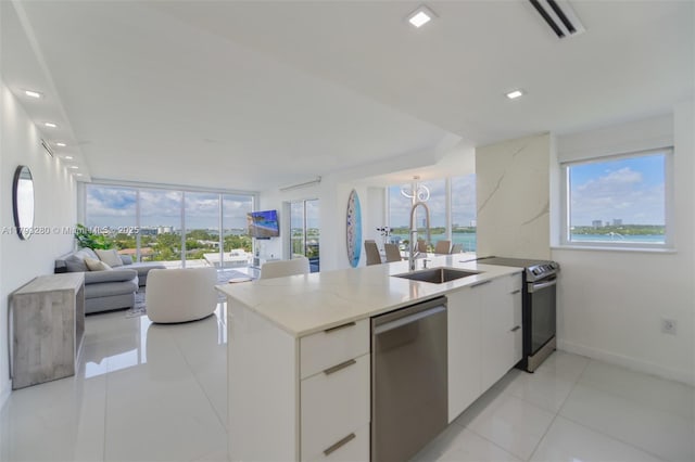 10275 Collins Ave Unit 731, Bal Harbour, FL 33154 - kitchen featuring stainless steel appliances, modern cabinets, white cabinetry, a sink, and light tile patterned floors
