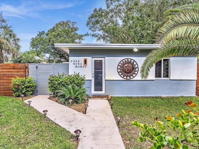 view of front of property with fence and a front lawn