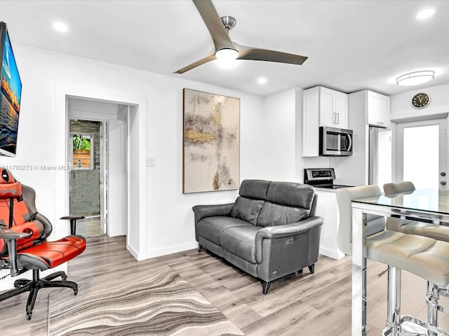 living area featuring recessed lighting, baseboards, a ceiling fan, and light wood-type flooring