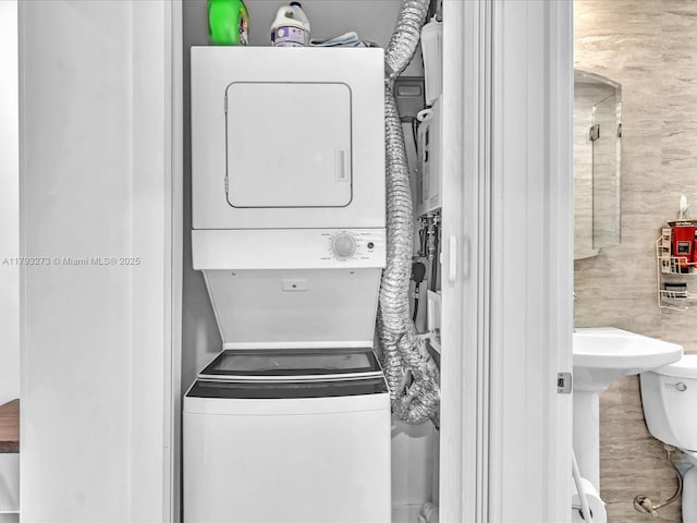 laundry area with laundry area and stacked washer / drying machine