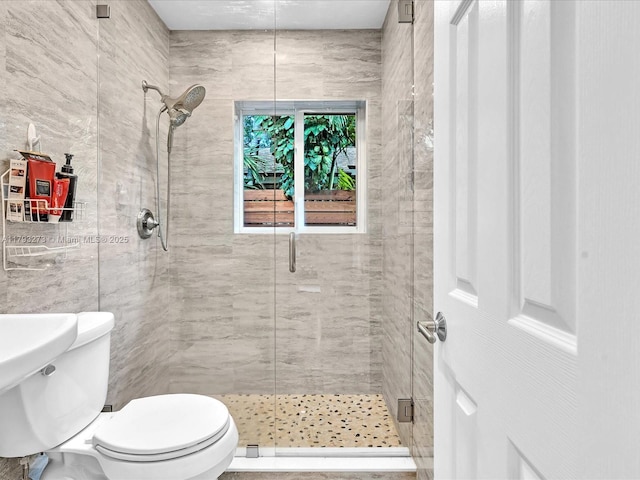 bathroom with a stall shower, toilet, and tile walls