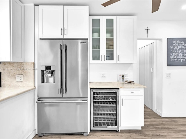 kitchen featuring high end fridge, white cabinetry, wine cooler, and light wood finished floors