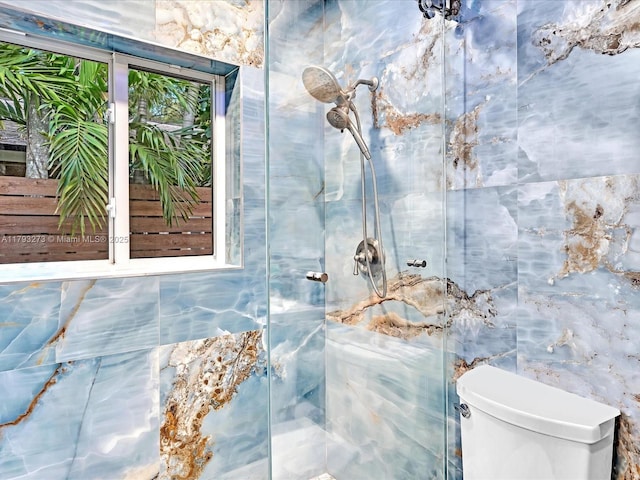 bathroom featuring tile walls, a shower with door, and toilet