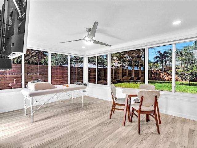 sunroom / solarium with a deck, baseboards, recessed lighting, and wood finished floors