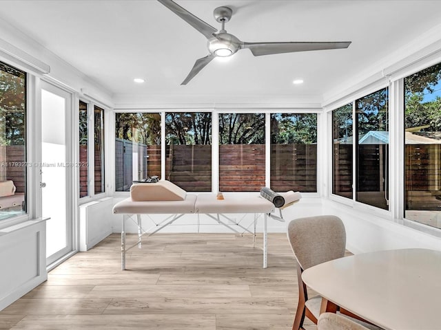 sunroom featuring recessed lighting, wood finished floors, and a deck