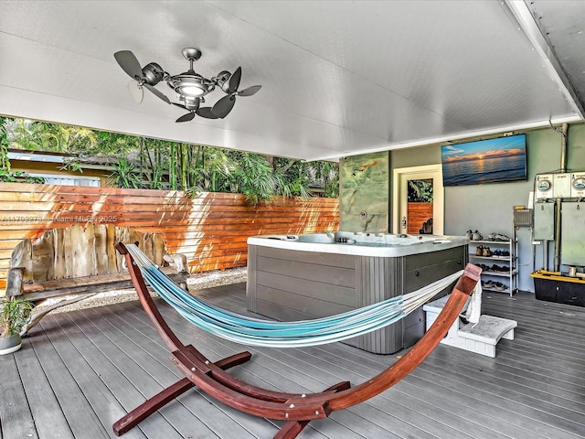 wooden terrace featuring a hot tub and fence
