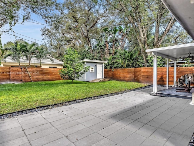 view of patio featuring an outdoor structure, a fenced backyard, and a shed