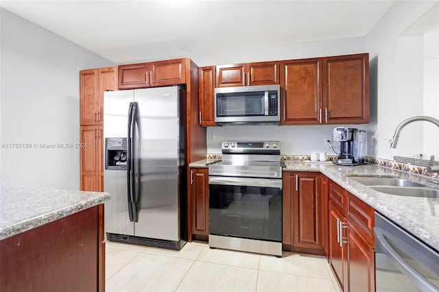 2767 S Carambola Cir S Unit 506, Coconut Creek, FL 33066 - kitchen with stainless steel appliances, a sink, light tile patterned floors, and light stone countertops