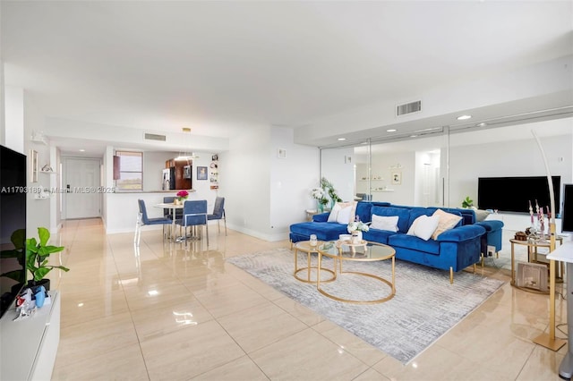 living area featuring visible vents, baseboards, and light tile patterned floors