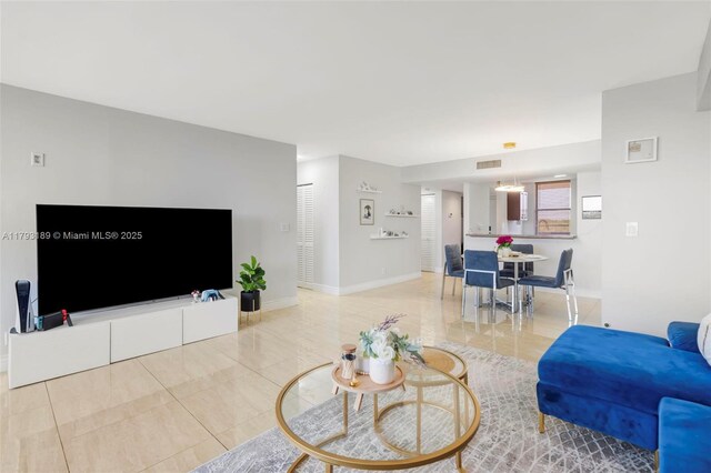 living room with baseboards, light tile patterned floors, and visible vents
