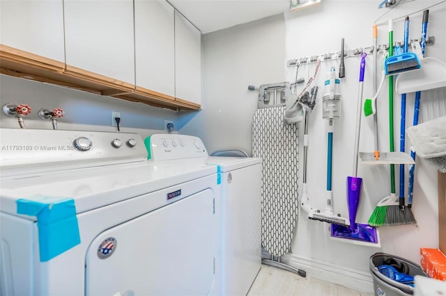 laundry room featuring independent washer and dryer and cabinet space