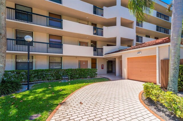 2767 S Carambola Cir S Unit 506, Coconut Creek, FL 33066 - view of apartment building / complex featuring a garage and decorative driveway