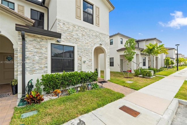 12901 SW 232nd Ln, Homestead, FL 33032 - view of front of home featuring a residential view, stucco siding, a front yard, and stone siding