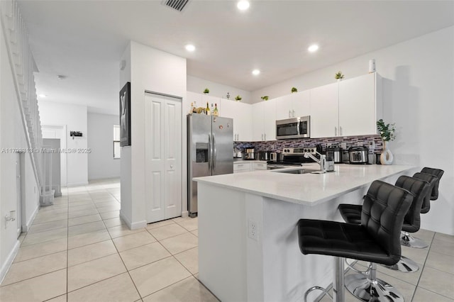12901 SW 232nd Ln, Homestead, FL 33032 - kitchen featuring tasteful backsplash, light countertops, a sink, a peninsula, and stainless steel appliances