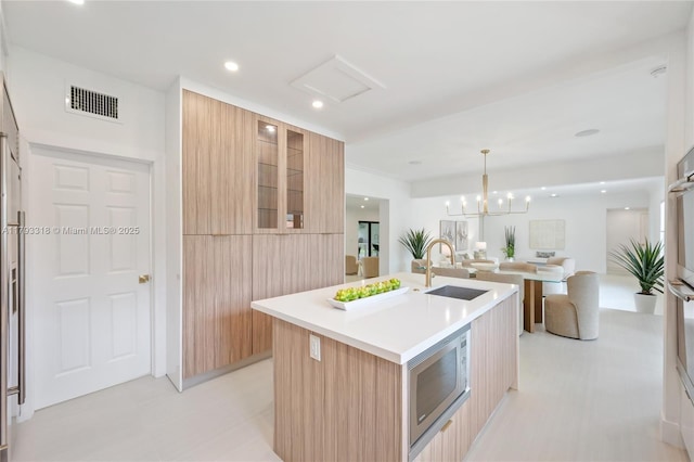 1375 SW 17th Ter, Miami, FL 33145 - kitchen with modern cabinets, a sink, stainless steel microwave, a center island with sink, and recessed lighting