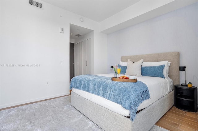 398 NE 5th St Unit 2517, Miami, FL 33132 - bedroom with baseboards, a closet, wood finished floors, and visible vents