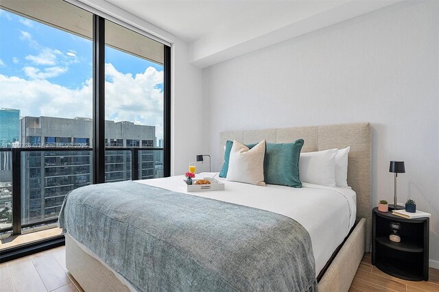 398 NE 5th St Unit 2517, Miami, FL 33132 - bedroom featuring a city view, floor to ceiling windows, and wood finished floors