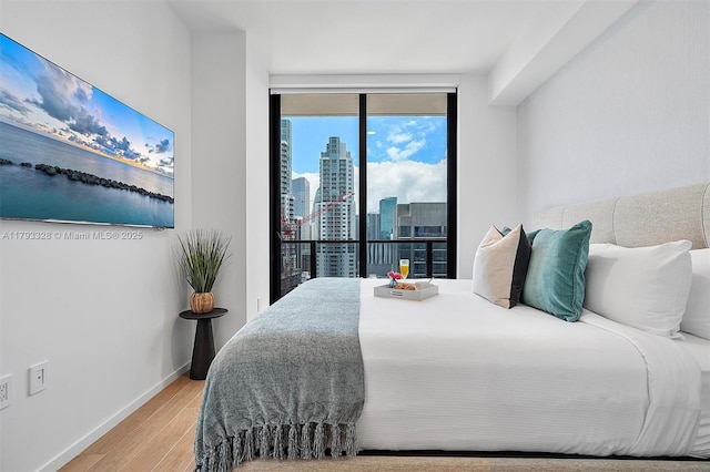 398 NE 5th St Unit 2517, Miami, FL 33132 - bedroom with baseboards, a city view, and wood finished floors
