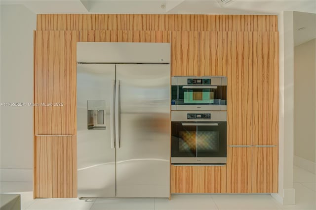 kitchen featuring stainless steel appliances and light tile patterned flooring